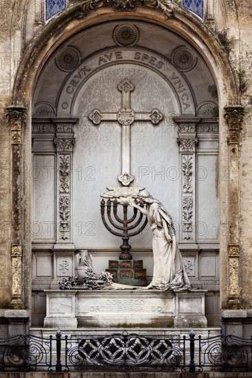An artistically designed tomb with a statue and a cross in the centre, La Recoleta cemetery in