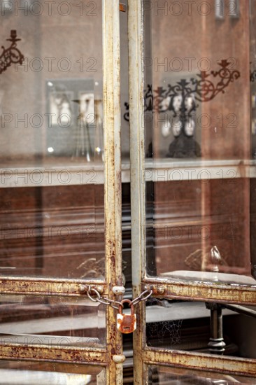 Old rusted metal gate with chain and padlock in an urban environment, La Recoleta cemetery in