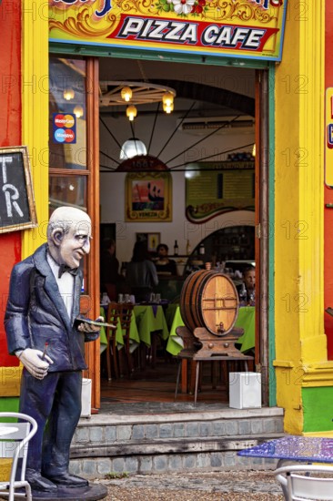 A café with a colourful façade and a sculpture in front of the entrance, inviting interior, The