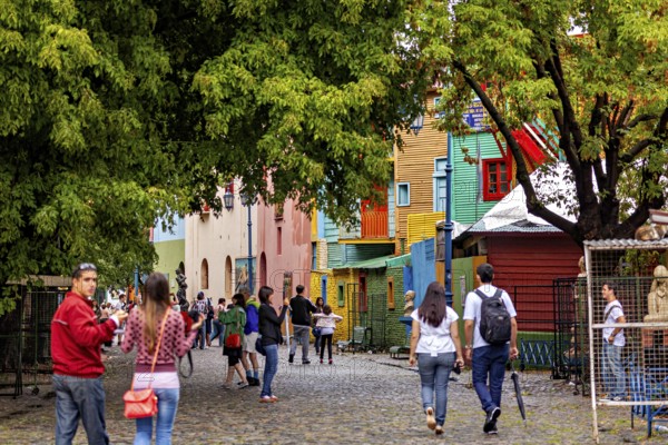 People walking on a colourful street with colourful houses and trees in an urban environment, The