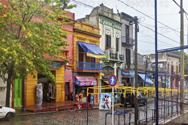Lively street with colourful buildings and wet cobblestones on a cloudy day, The colourful city and