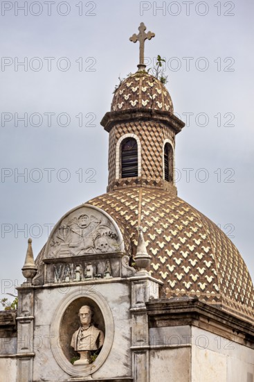 Historic structure with decorative dome, cross and a bust in an ornate relief, La Recoleta cemetery