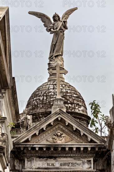 Angel sculpture on decorated dome above a historic building with Gothic design, La Recoleta