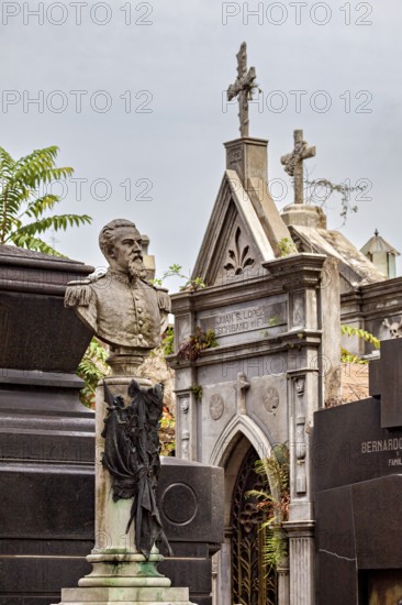 Monumental bust of a man in a cemetery, surrounded by historic tombs, La Recoleta Cemetery in