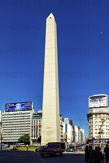 An obelisk in sunny weather in a busy city centre with traffic in the foreground, The large obelisk