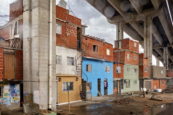 Brick houses under a bridge with a dull sky in an urban environment, The colourful city and tango