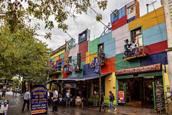 A colourful façade full of artists and shops attracts people despite the rain clouds, The colourful
