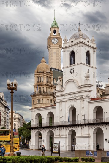 Centrally located colonial-style buildings with prominent clock towers and clouds in the sky,