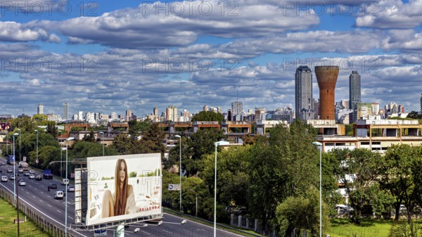 Cityscape with skyscrapers, a large billboard and busy traffic under a cloudy sky, The city of