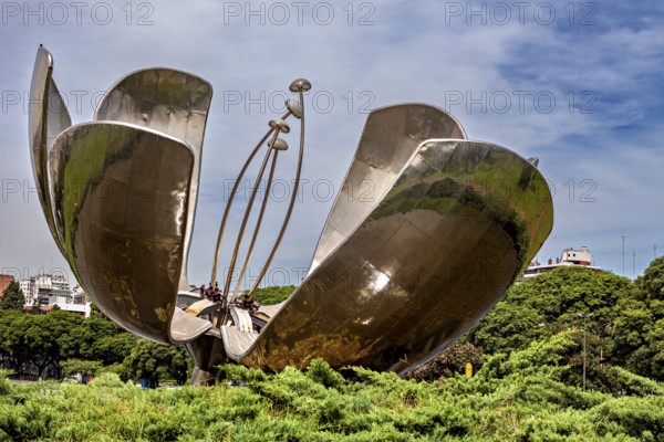 Modern sculptural flower surrounded by vegetation, with elements representing the pistil, The lotus