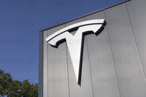 Tesla, logo on modern workshop building, figurative mark without lettering, US car manufacturer for