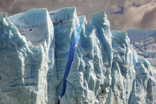 Majestic glacier wall under a cloudy sky in different shades of blue, The blue ice of the Perito