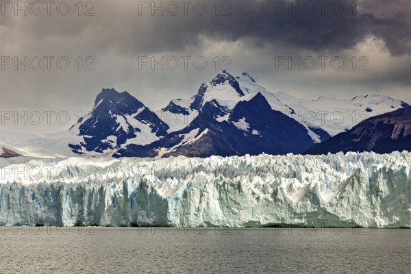 A powerful view of snow-covered mountains and glaciers under a gloomy sky, The Perito Moreno