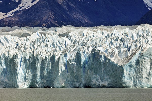 Detailed view of a massive blue glacier against a mountain backdrop, The Perito Moreno glacier in