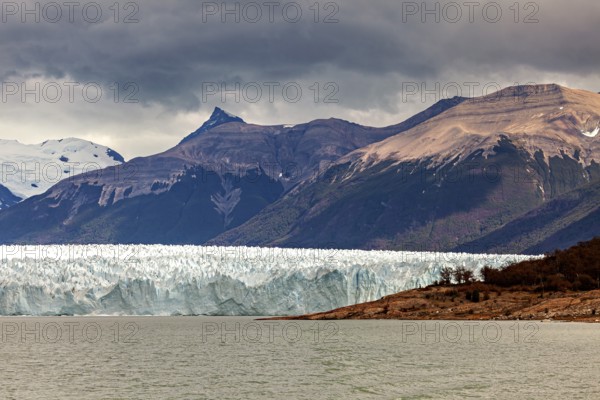 Impressive glacier front with dramatic sky and mountainous backdrop, The Perito Moreno glacier in
