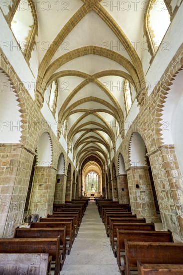 Interior view of a Gothic church with impressive arches and wooden rows of seats, The Abbey de La