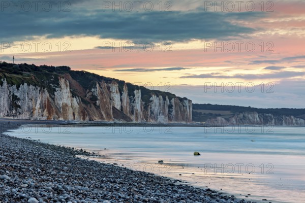 Dramatic cliff landscape with gentle sea coast at sunset with atmospheric sky, The cliffs near