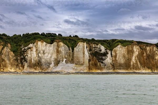 Imposing rocks on the coast with calm sea and cloudy sky, The coast of Dieppe in Normandy, France