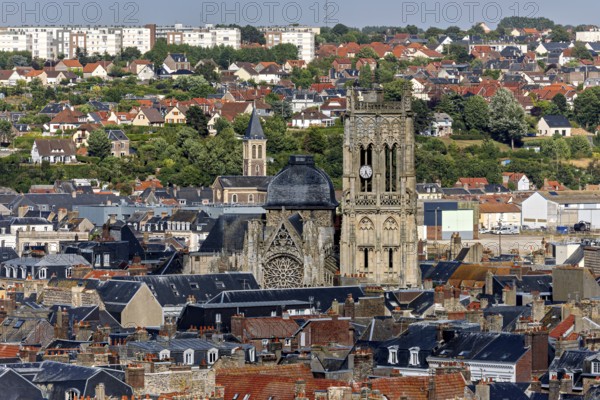Town view with striking church tower surrounded by old tiled roof houses and green surroundings,