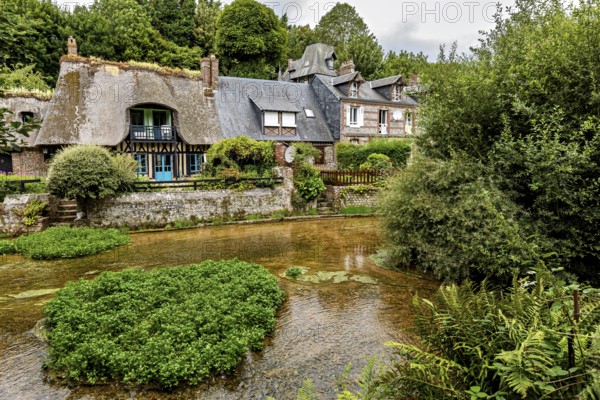 Picturesque village on a river with half-timbered houses and lush nature, the historic mill village