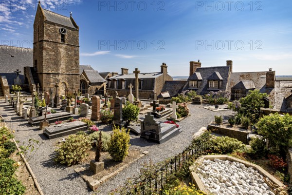 A peaceful cemetery next to a church with gravestones and flowers under a clear blue sky, The