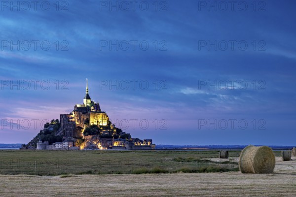 Mont Saint-Michel at dusk, illuminated with straw bales in the foreground, Mont Saint Michel in