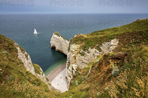 Green cliffs with sailing boat in the sea and small beach bay, The cliffs and alabaster coast of