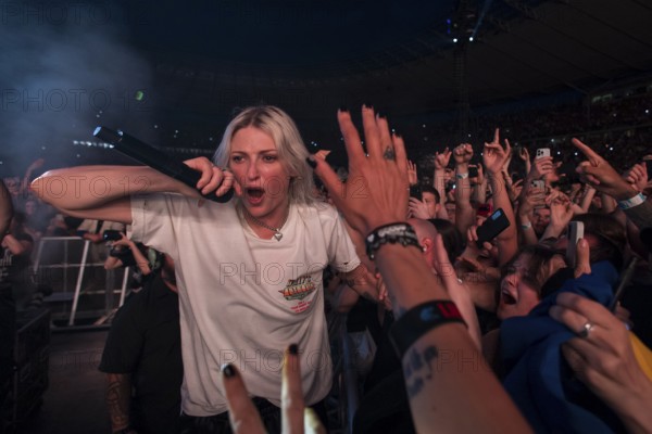 Emily Armstrong, lead singer of Linkin Park in the photo pit between the audience live on From Zero