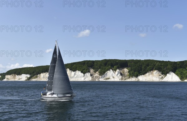 Sailing boat passes the chalk coast of Rügen, Mecklenburg-Vorpommern, Germany