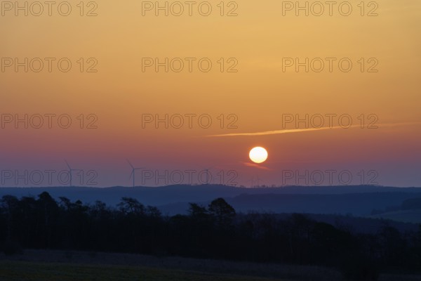 Landscape with sunrise over silhouettes of wind turbines on the horizon, Sodenberg, Hammelburg,