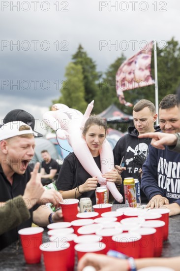 Festival visitors play a drinking game on a campsite at the Rock am Ring Festival on Saturday,