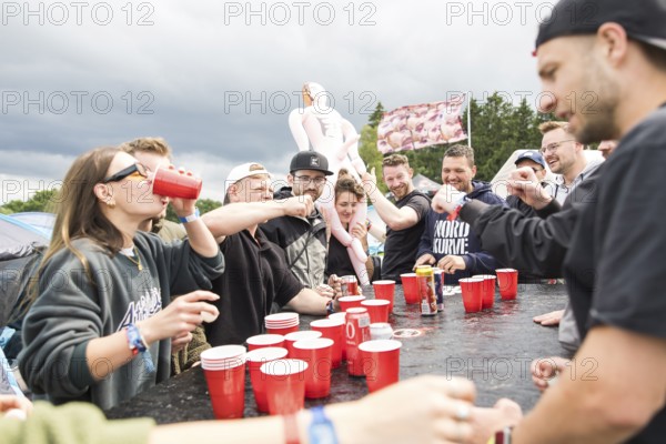 Festival visitors play a drinking game on a campsite at the Rock am Ring Festival on Saturday,