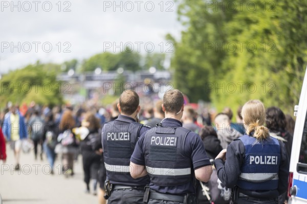 Police officers watch festival visitors on their way to the main entrance at the Rock am Ring