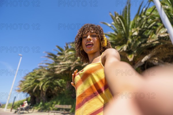 Carefree young woman enjoying summer holidays taking a selfie while listening to music with