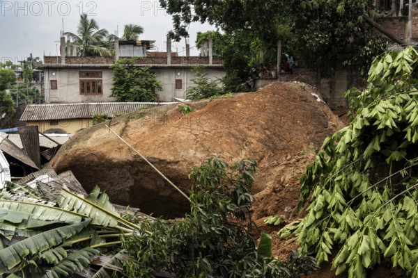 Large rock slides from the top of a hill and damaged houses in a major landslide, triggered by a