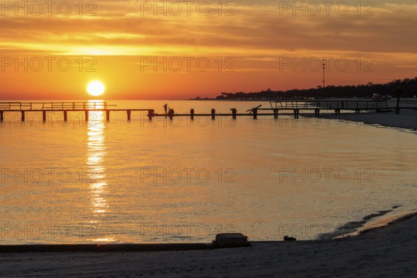 Sunset behind dilapidated fishing pier damaged by hurricanes on the Mississippi Gulf Coast in Long