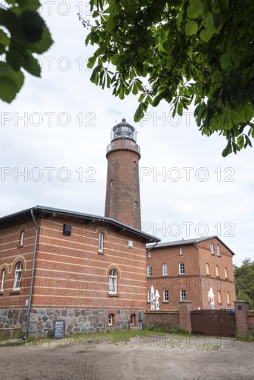 Lighthouse Darßer Ort, brick lighthouse next to a historic building, surrounded by trees under a