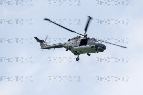 Naval helicopter flies in front of a clear sky, majestic and technical, Prerow,
