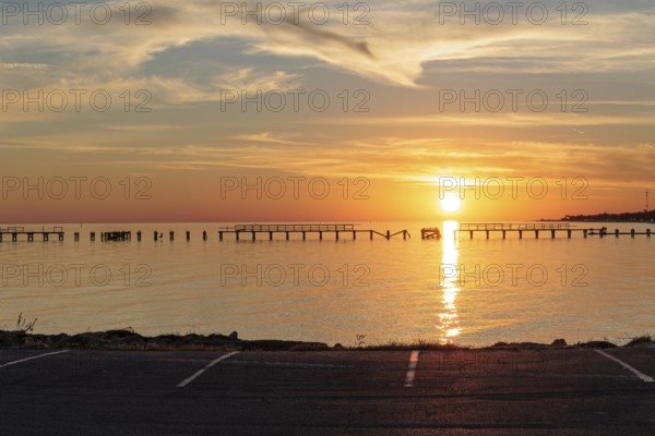 Sunset behind dilapidated fishing pier damaged by hurricanes on the Mississippi Gulf Coast in Long