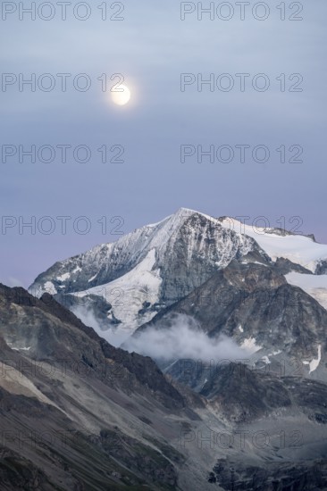 Summit Mont Blanc de Cheilon with glaciers, evening mood, moon stands over mountain peaks at the