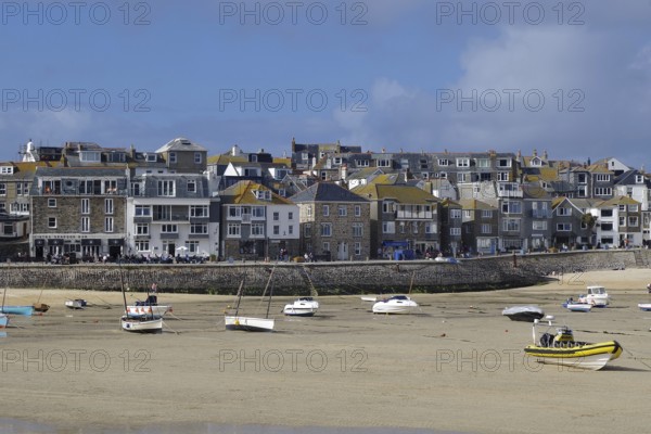 A busy coastal harbour with many boats and a town with densely built houses, St Ives, Cornwall,