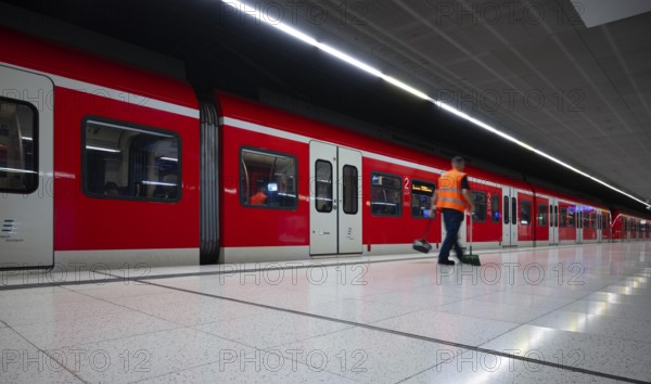 Underground arriving S-Bahn, train, class 420 in traffic red, cleaner cleans platform, cleaning,