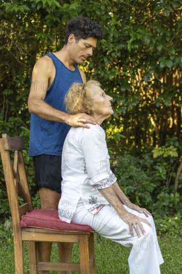 Physiotherapist is guiding a senior woman through posture exercises, providing support and gentle