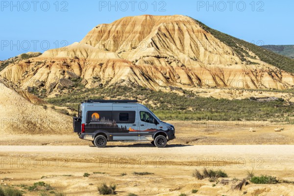 Camper van, colorful rock formation, semi-desert, Bardena Blanca area, Bardenas Reales Nature Park,