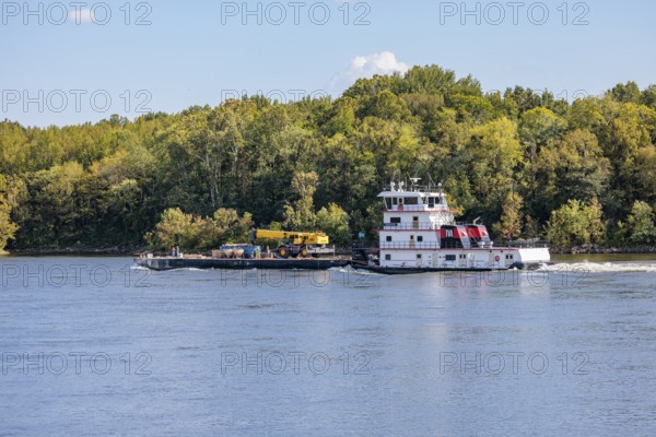 Tennessee Valley Authority tug boat Freedom pushing a barge with construction equipment upstream on