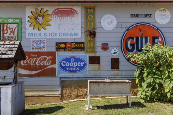 Antique metal advertising signs used for decoration on the side of a building near Counce,