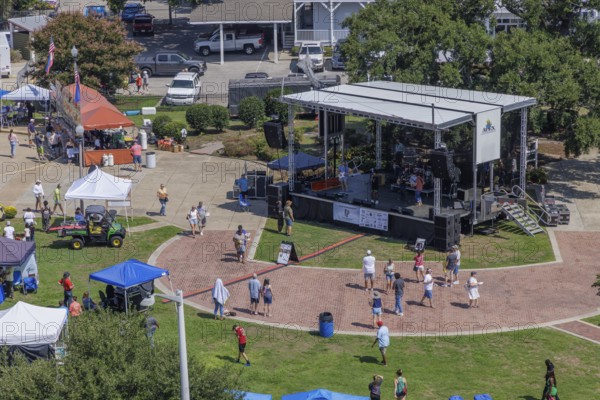 Visitors being entertained with live music at the bandstand during the Biloxi Seafood Festival in