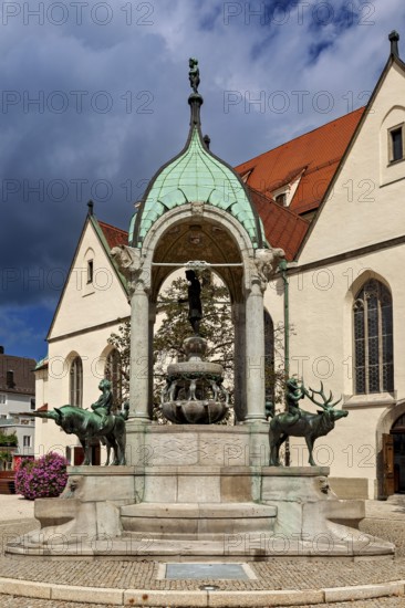 Magnificent fountain with figures in front of historic church, The town of Kempten im Allgäu