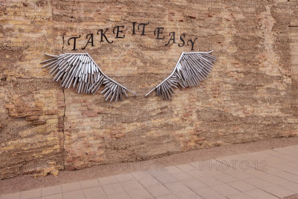 Metal tubular art on brick wall for tourists to pose for pictures at Standin' on the Corner Park in