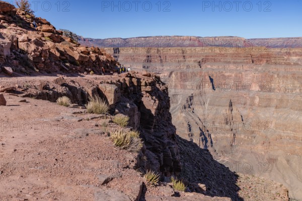 Visitors walk along the canyon rim to the location of the old mining cable structure at Guano Point